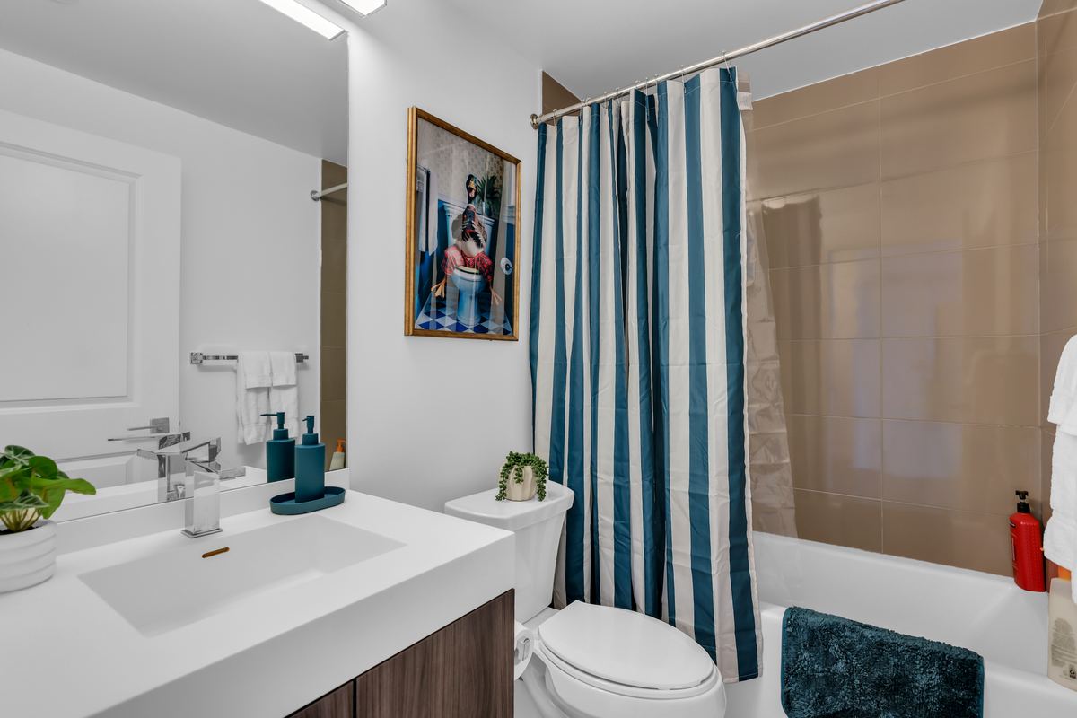 Bathroom with a full tub and shower, fresh towels and toiletries