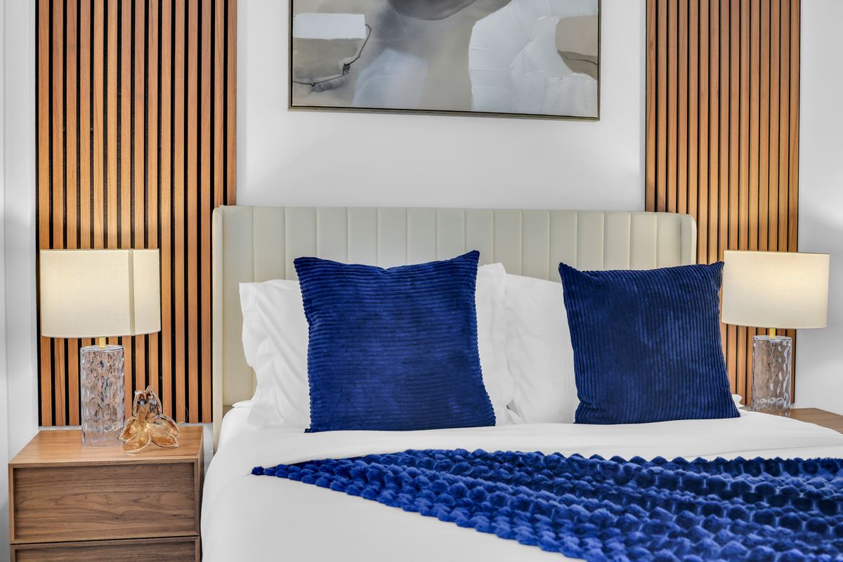 Close view of the bed with pillows and bedside lighting